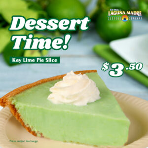 Laguna Madre logo. Dessert time! A key lime pie slice is $3.50. The price is subject to change. The image features a slice of key lime pie with a dollop of whipped cream, served on a small beige plate. The background features lime slices and whole lime with a blurred overlay background.